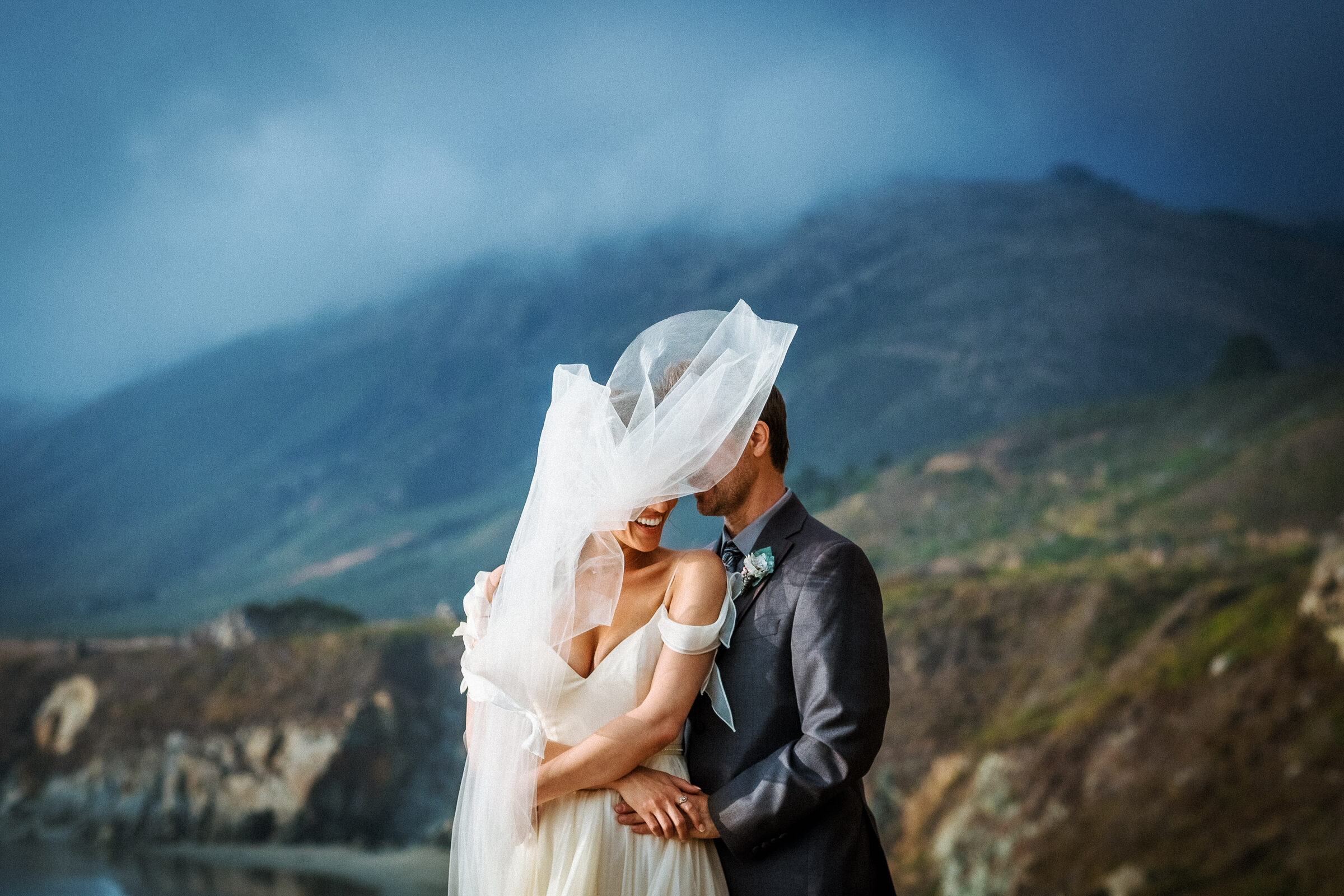 Timeless Big Sur wedding portrait of a bride and groom embracing on the California coast