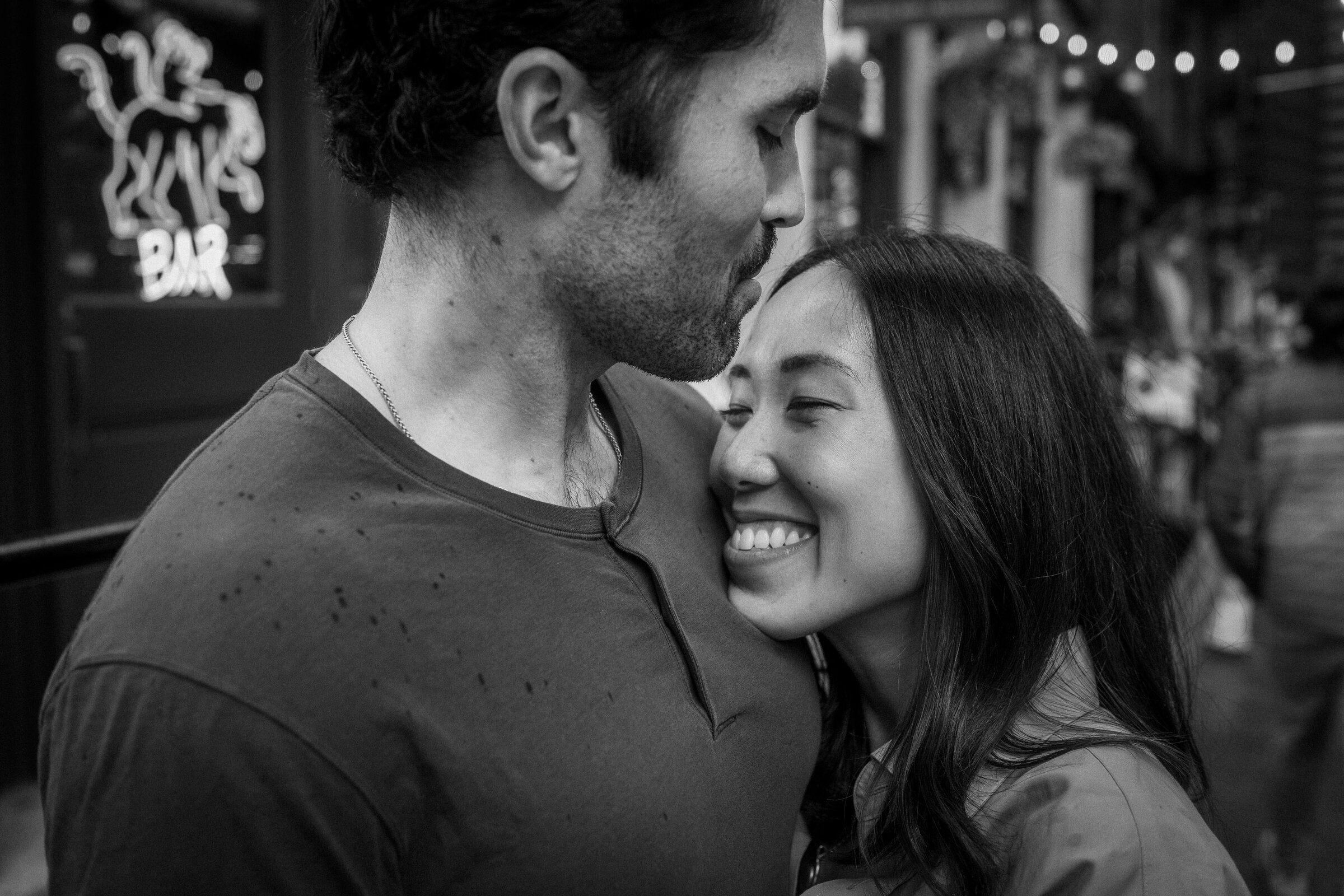 Cinematic black-and-white engagement portrait of a couple sharing a quiet embrace