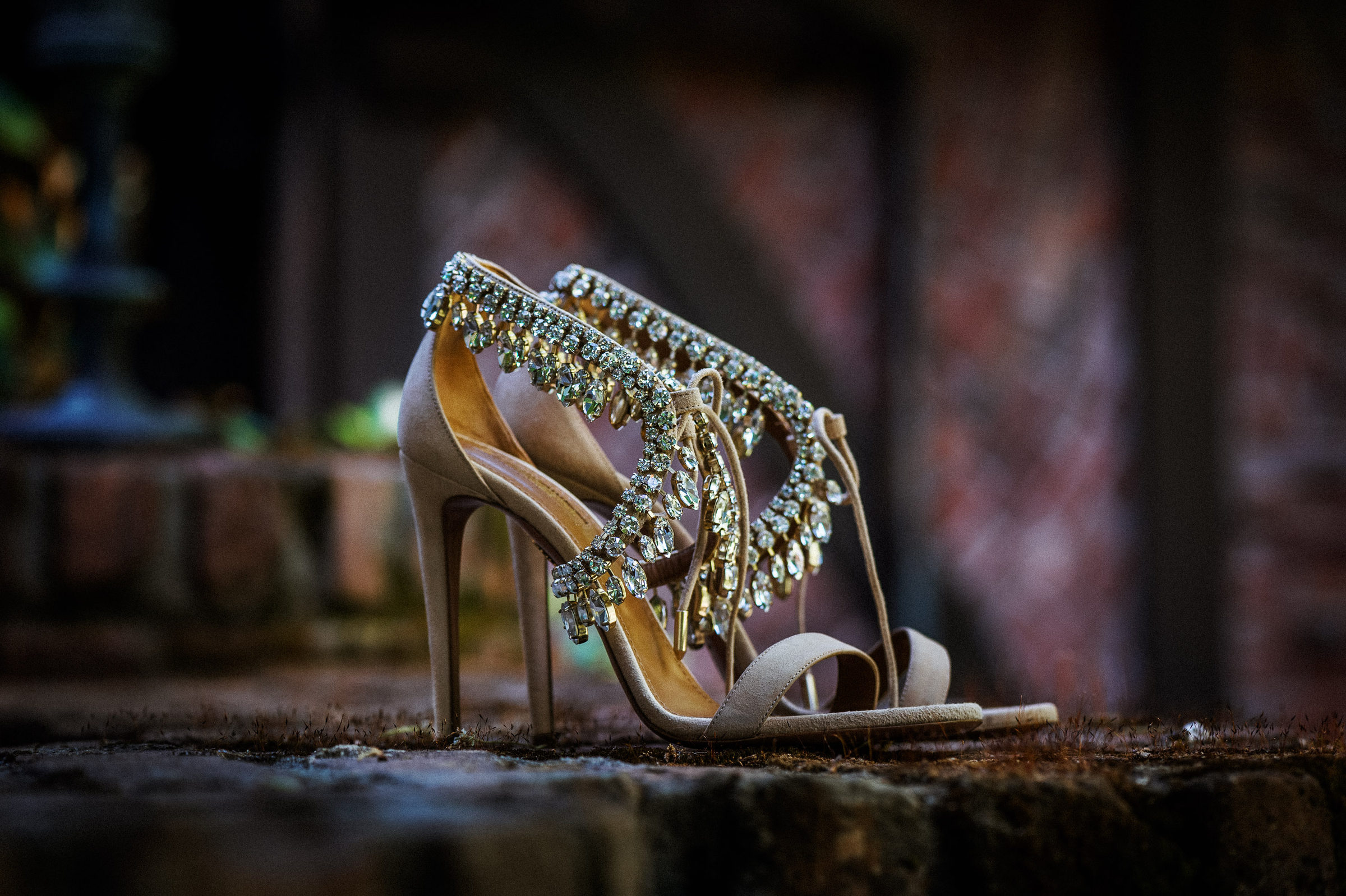 Jeweled bridal heels resting on a brick step