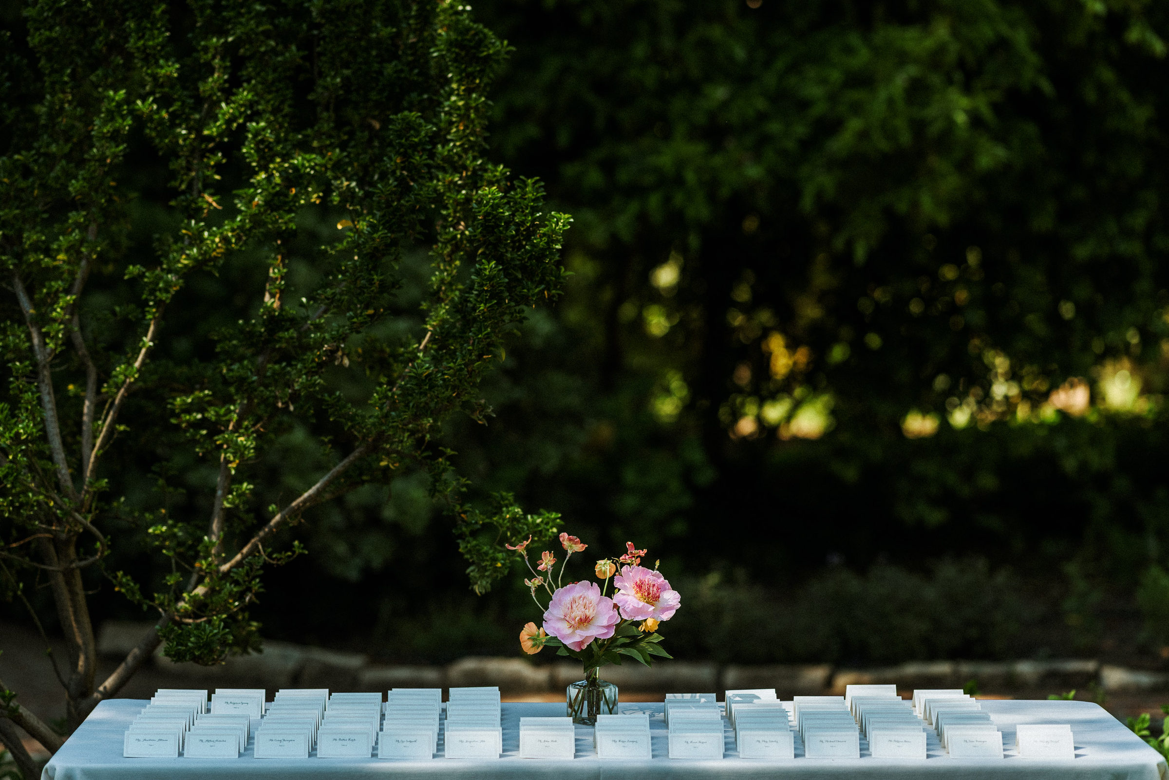 Escort cards laid out on a linen table in the garden