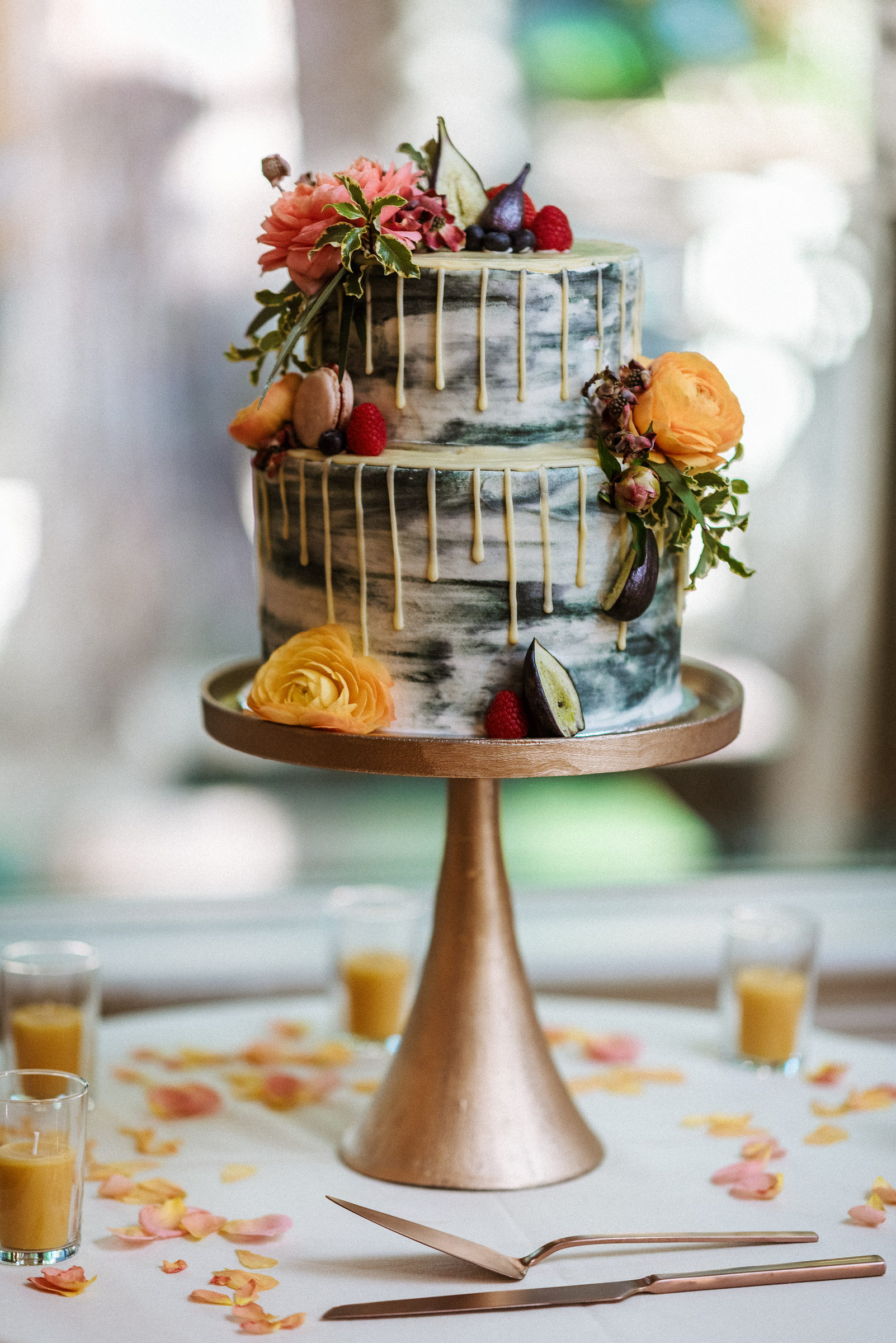 Two-tier wedding cake trimmed with fresh flowers and figs