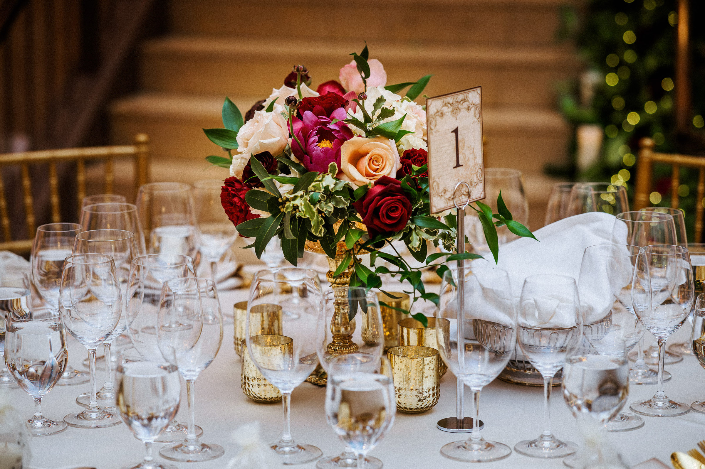 Table number and rose centerpiece before the Bently Reserve staircase