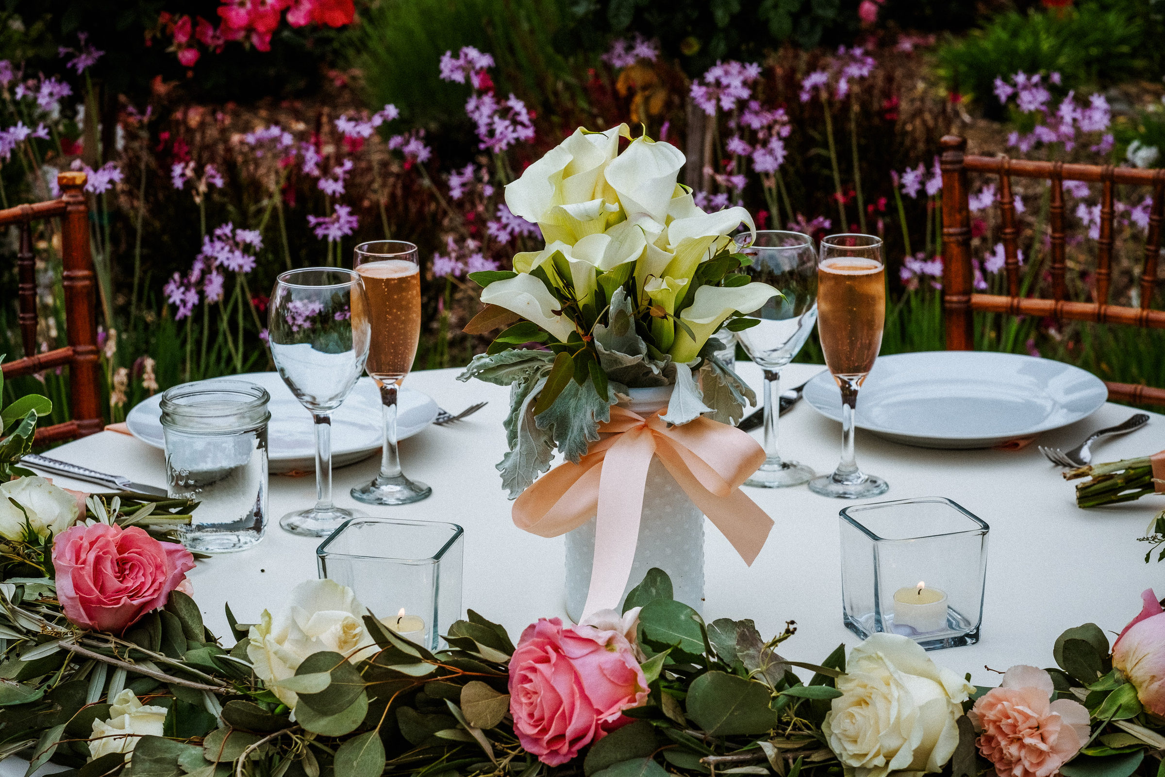 Calla lily centerpiece and rose garland on the sweetheart table