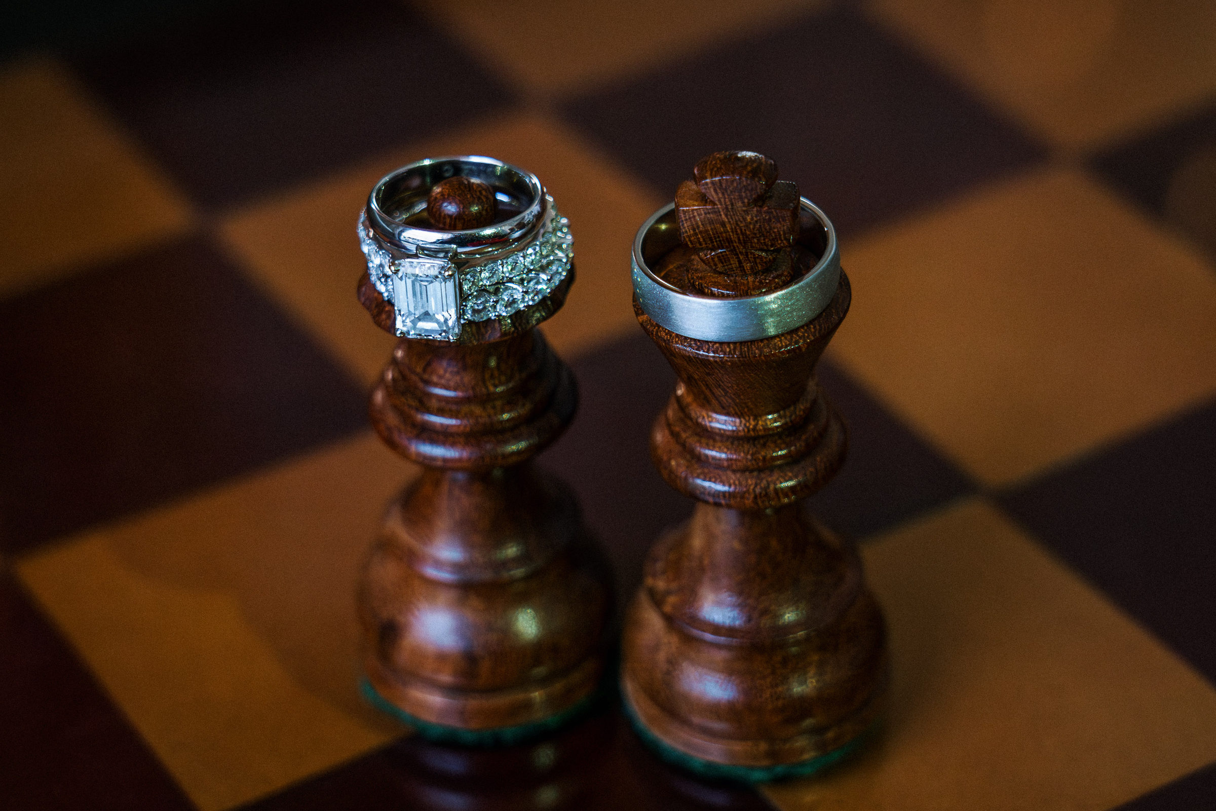 Wedding rings resting on carved king and queen chess pieces