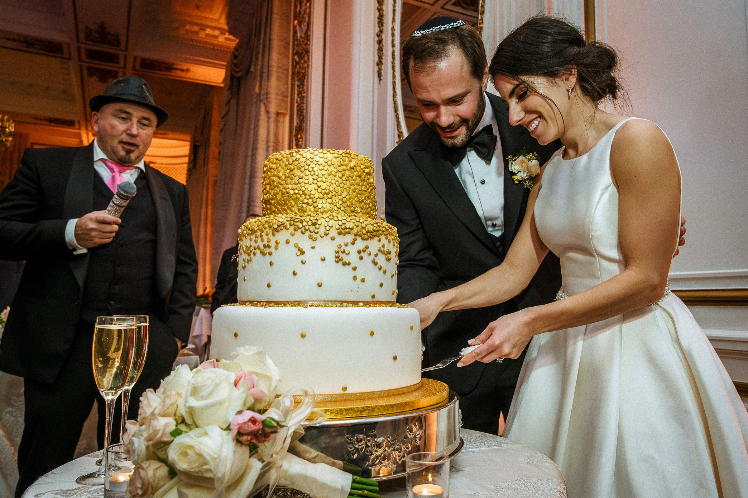 Newlyweds cutting their gold-dusted wedding cake at The Palace Hotel