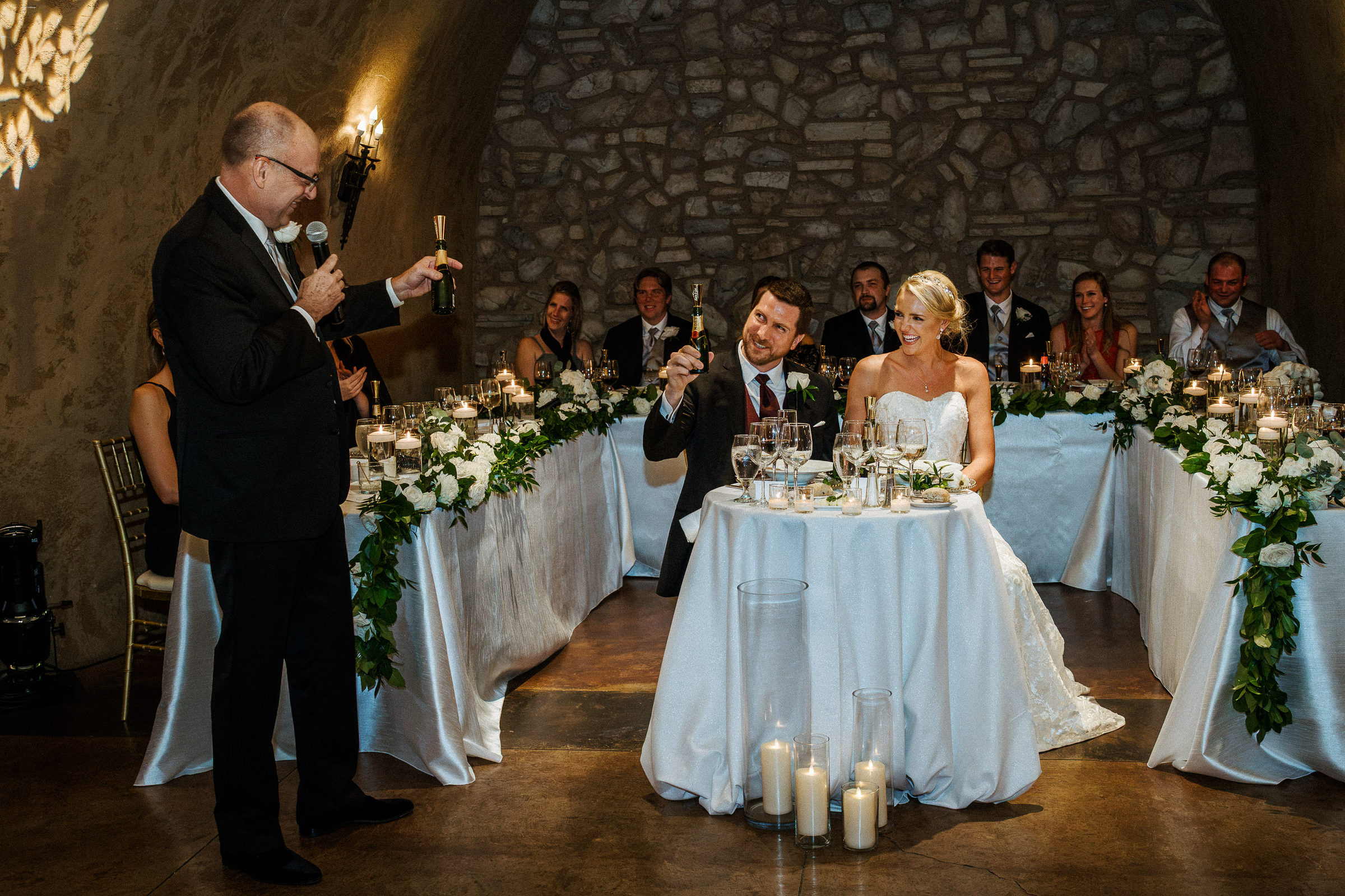 Toast to the newlyweds at their sweetheart table in the Estate Cave