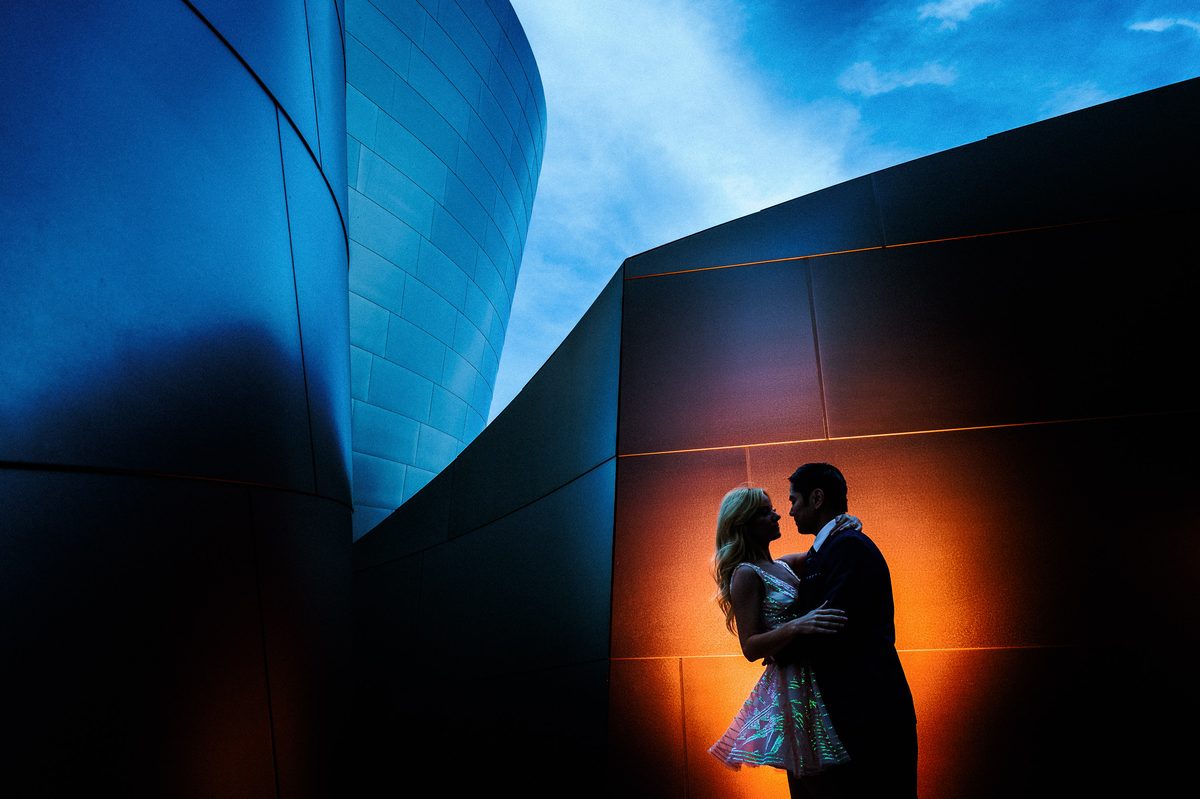 Silhouetted engaged couple against the glowing architecture of Walt Disney Concert Hall in Los Angeles