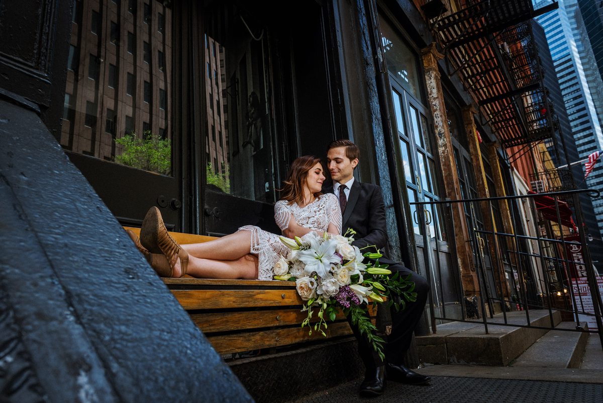Bride and groom seated on brownstone steps during a New York City wedding portrait session