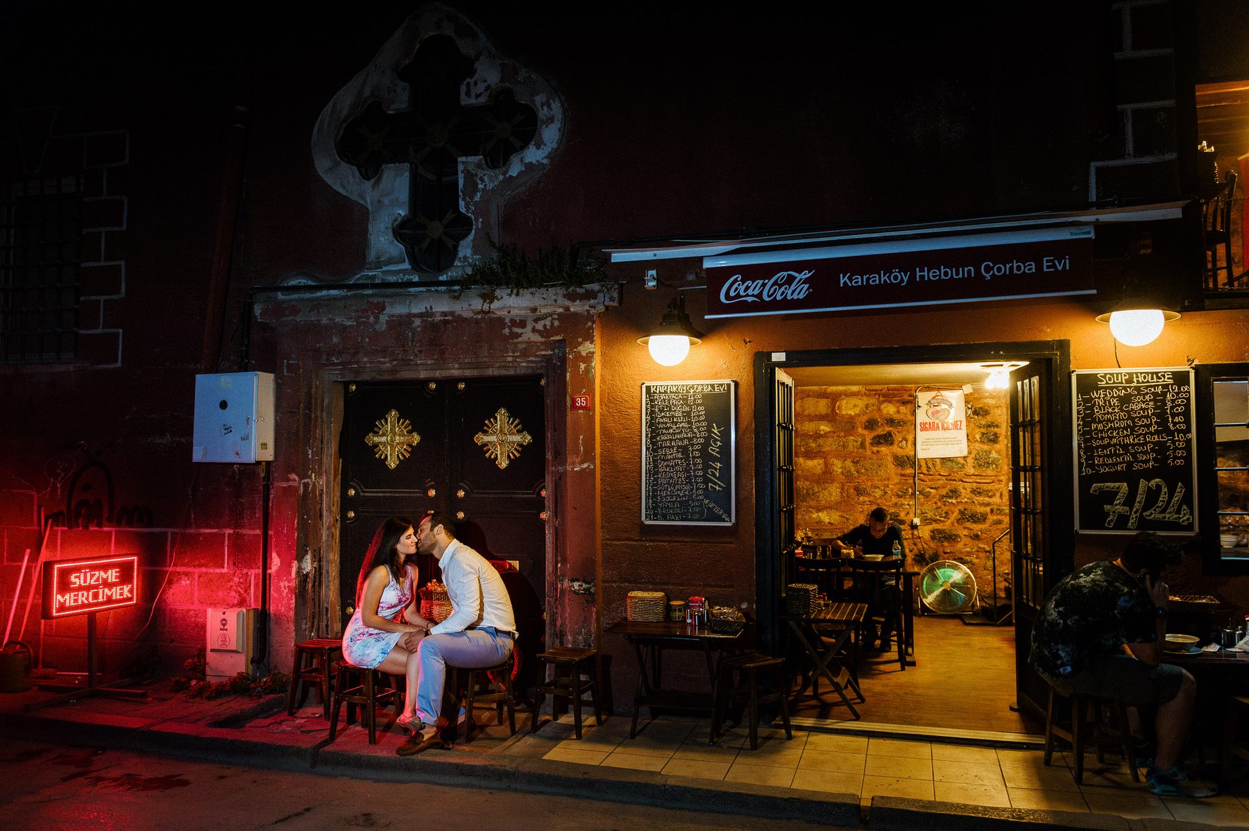 Engaged couple kissing outside a café in Karaköy during an Istanbul engagement session