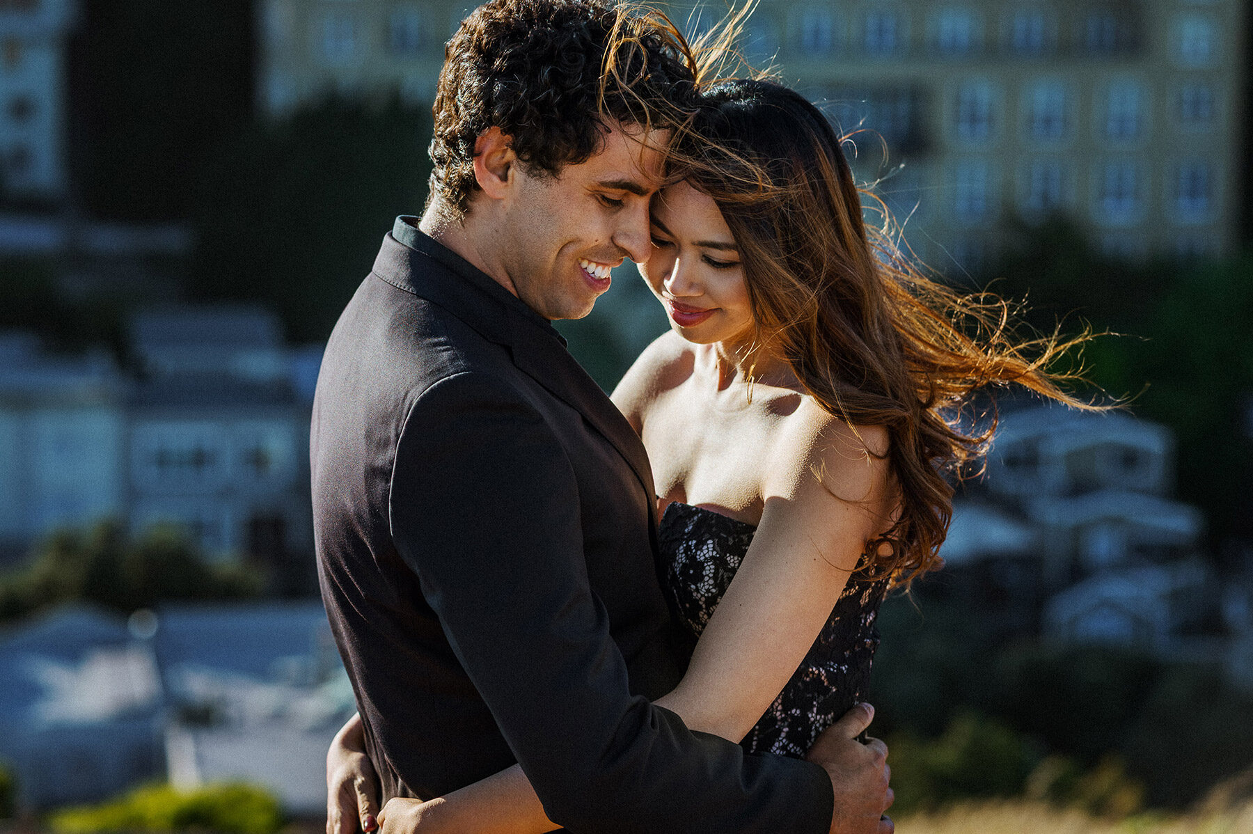 Engaged couple embracing in afternoon light during a San Francisco engagement session