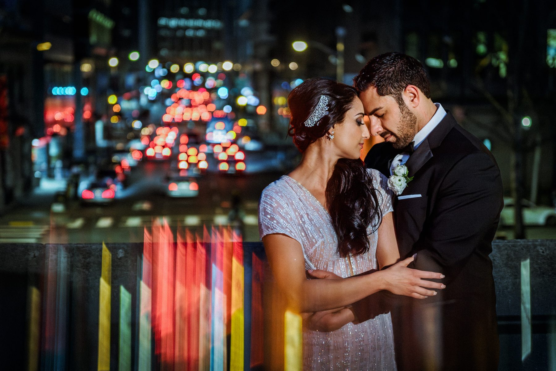 Bride and groom embracing above the lights of San Francisco's Financial District after their Bently Reserve wedding